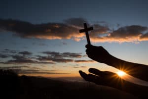 silhouette hand hold cross god